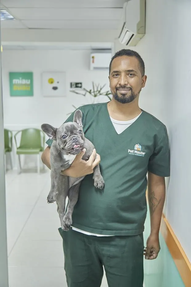 Auxiliar da Pet Master com um bulldog francês no colo